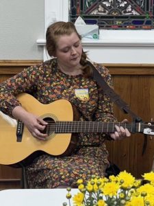 As members entered the Fellowship Hall, they were welcomed by acclaimed scholar of Appalachian folk music, Olivia Phillips, who sang and accompanied herself on the guitar.